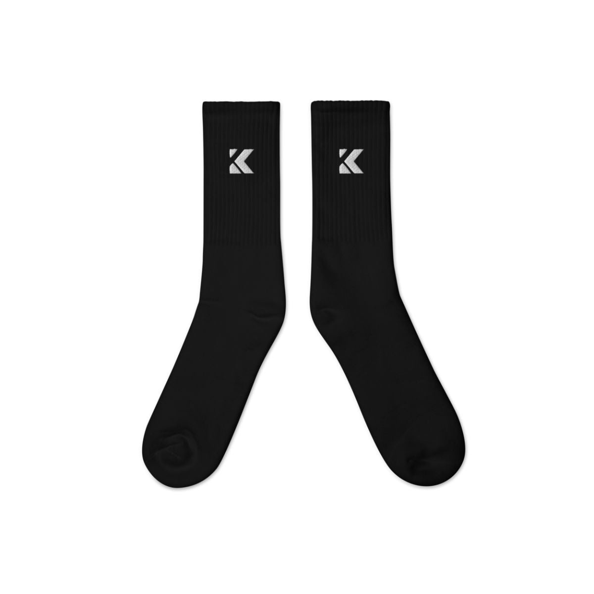 Pair of black socks with a white kicks logo on a white background